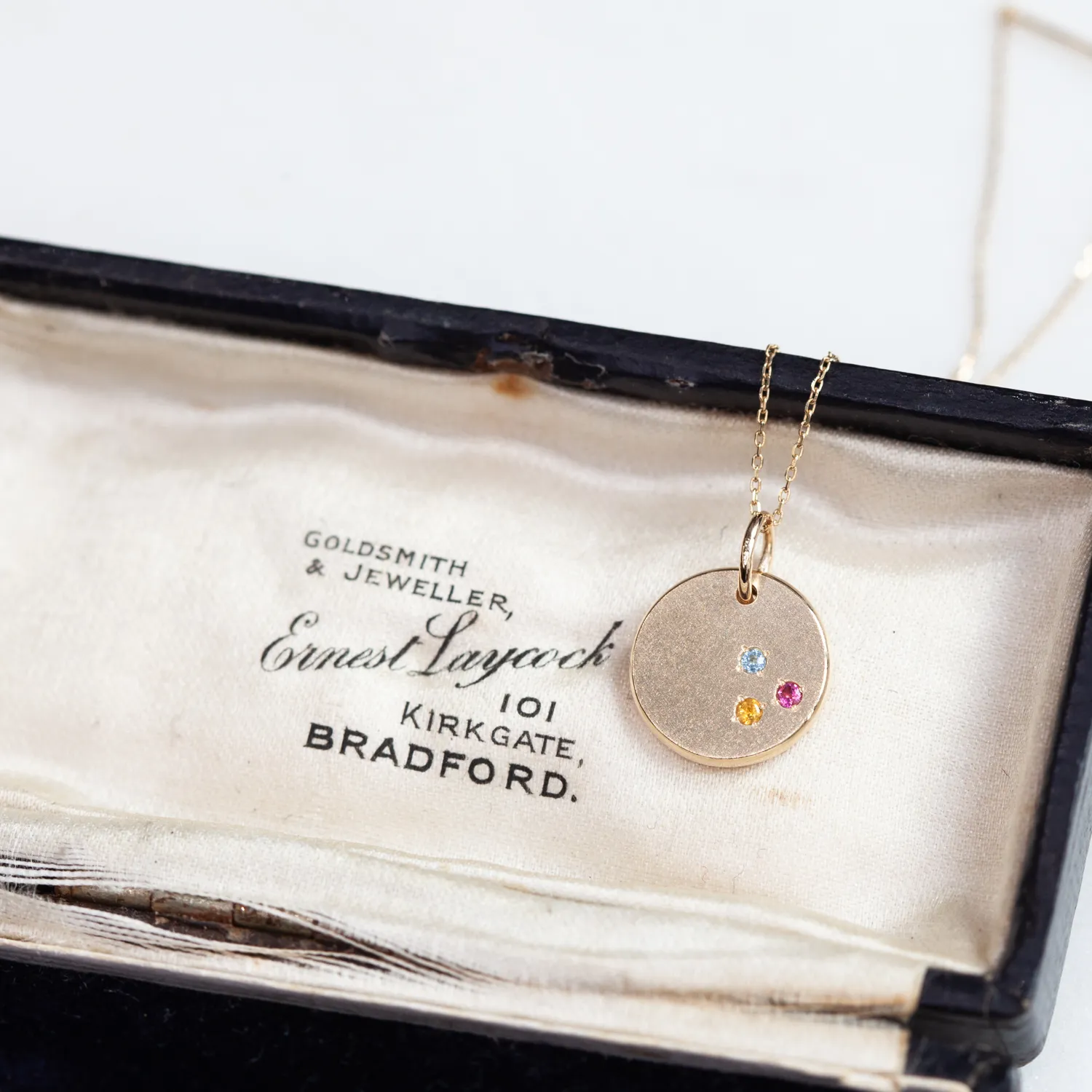 誕生石とイニシャルのリバーシブルなペンダントトップ